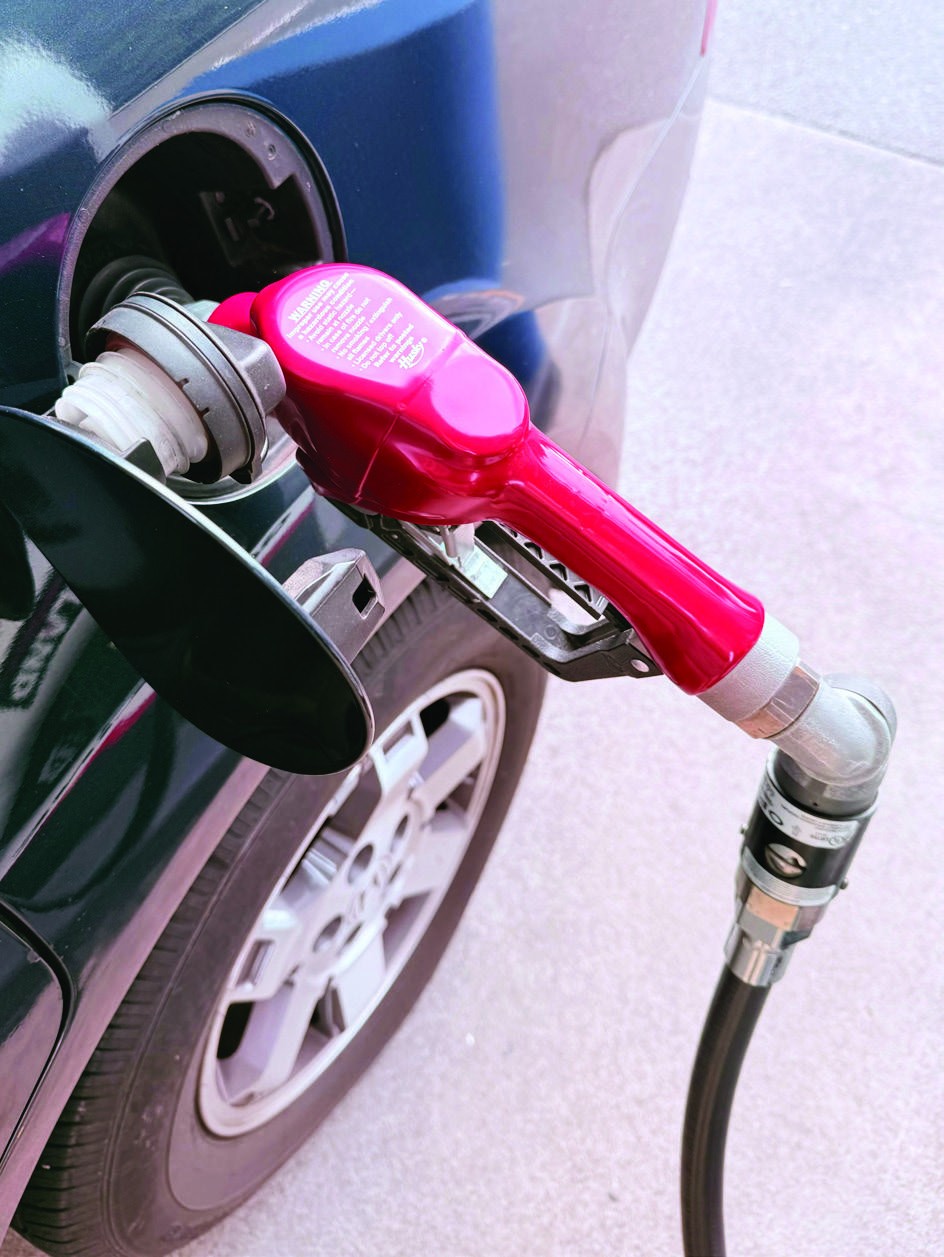 A fuel nozzle filling a vehicle